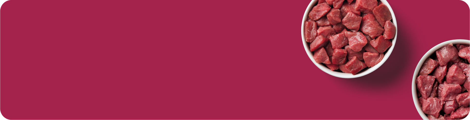 Two white bowls filled with raw beef cubes are placed on a solid burgundy background, with most of the bowls visible in the top right corner.