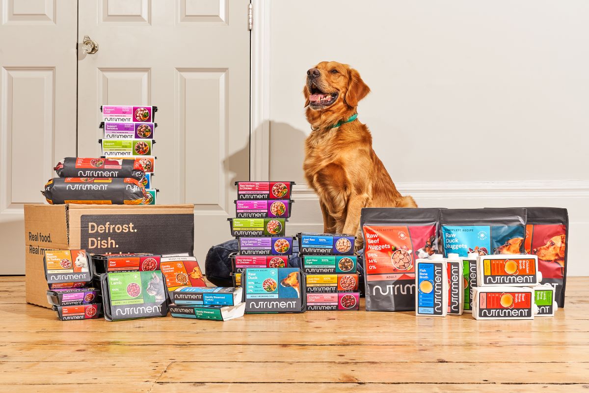 Dog standing behind the full range of Nutriment products