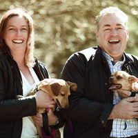 a couple holding two dogs