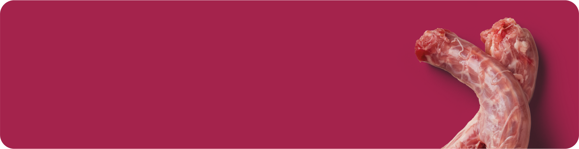 Two raw, uncooked turkey necks placed on a solid dark pink background, positioned in the lower right corner with ample empty space on the left.