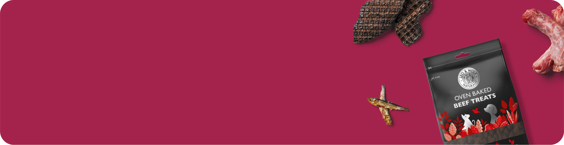 A package of oven-baked beef pet treats, dried fish, dried meat, and raw meat bones are arranged on a solid dark pink background, leaving space for text.