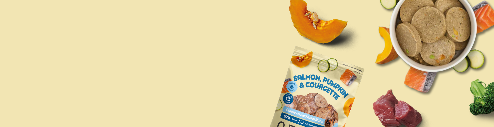 Two nutriment pet food packs with salmon, pumpkin, courgette, beef, and broccoli, shown alongside fresh salmon, beef, broccoli, and a pumpkin slice on a light yellow background.
