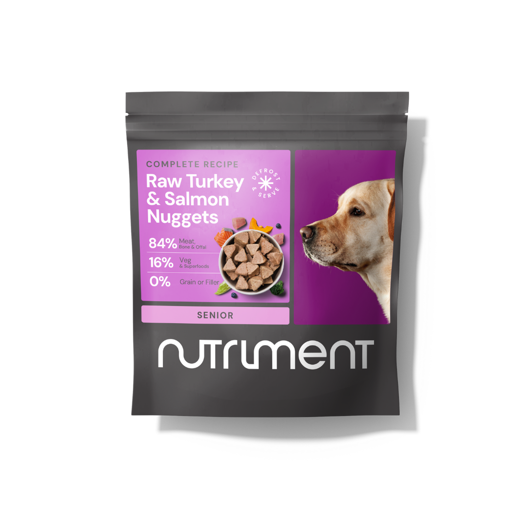 Black Nutriment bag labeled "Raw Beef Nuggets 1kg," grain-free pet food for senior dogs, with dog photo.