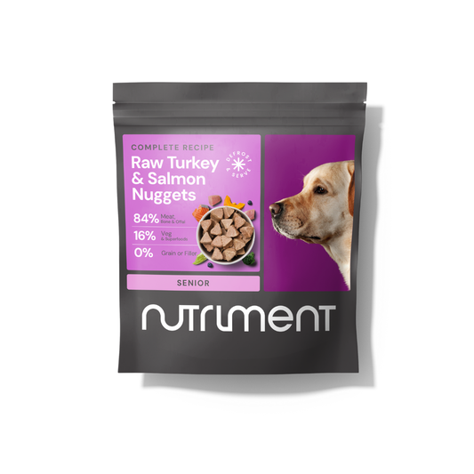 Black Nutriment bag labeled "Raw Beef Nuggets 1kg," grain-free pet food for senior dogs, with dog photo.