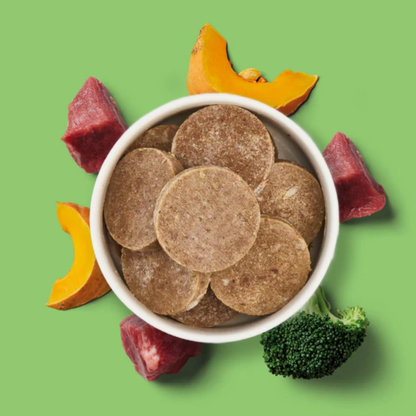 A bowl of Fresh Medallion Bundle (8 x 800g) patties with raw beef, pumpkin, and broccoli on green background.
