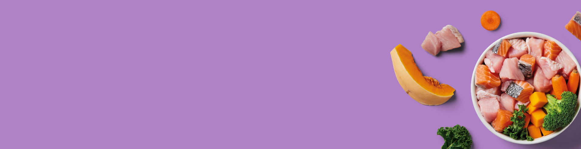 A bowl with raw salmon, vegetables, and kale on a purple background, scattered with more veggies and salmon pieces.